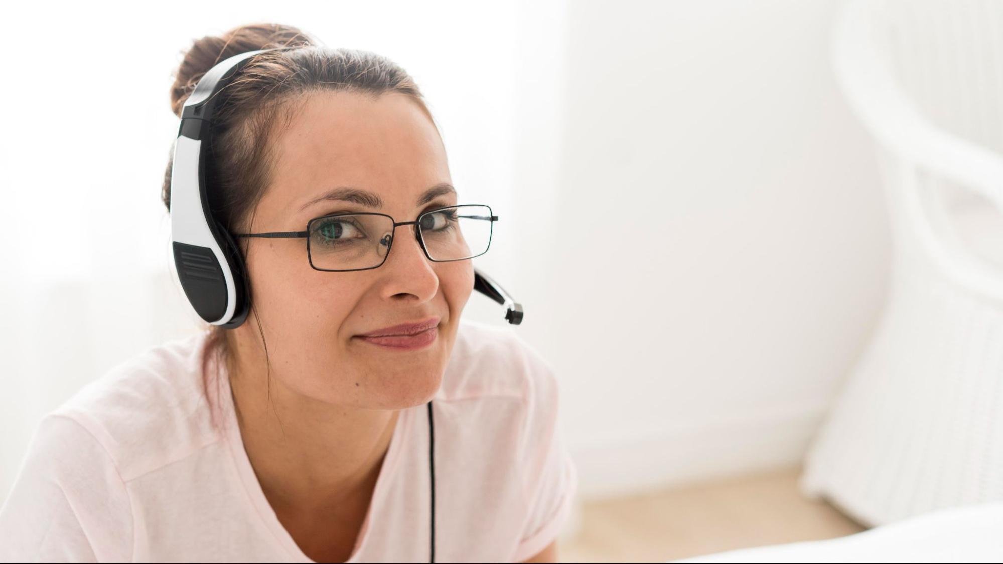A customer support agent wearing a headset makes direct eye contact, illustrating the human connection often missing in customer engagement solutions.